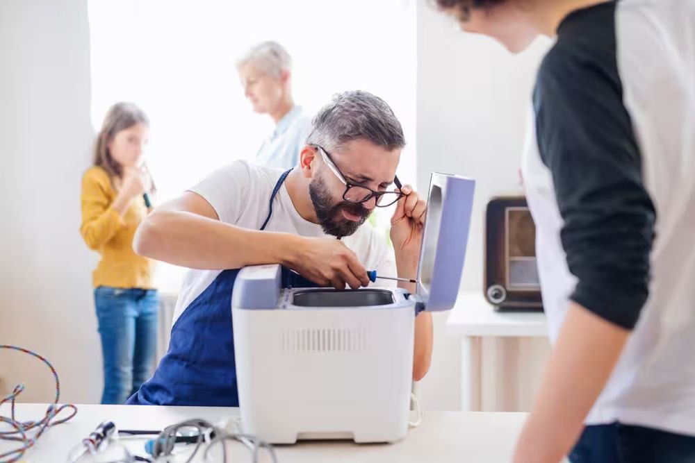 A man and woman work together on a 3D printer in a Reno, NV small appliance repair service.